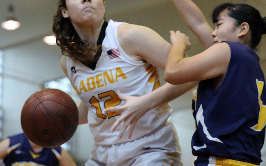 Kadena's Madison Shepard looks for room against a Kitanakagusuku defender during Sunday's girls third-place game in the 12th Okinawa-American Friendship Basketball Tournament. The Panthers beat the Fighting Lions 62-53.