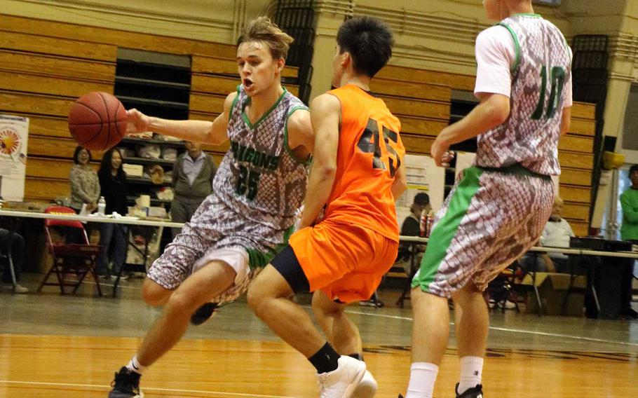 Kubasaki's Jonathan Baker drives around a Maehara defender as teammate Jonathan Hoppe sets a screen during Sunday's boys championship game in the 12th Okinawa-American Friendship Basketball Tournament. The Dragons downed the Fighting Bulls 68-54 for their fourth title in six finals appearances since the tournament's inception in 2007.