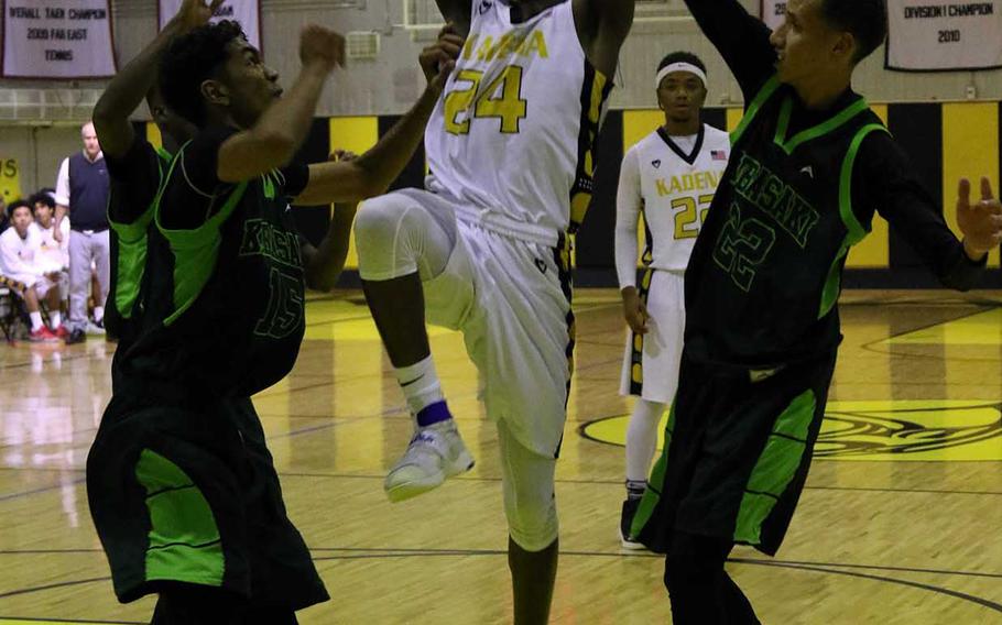 Kadena's Montez Young Jr. puts up a shot between Kubasaki's Ilijah Washington and Elonzo Higginson III during Friday's Okinawa boys basketball game. The Panthers outscored the Dragons 21-6 in the fourth quarter to win 59-51 and win the season series from Kubasaki 3-0 with one game left to play.