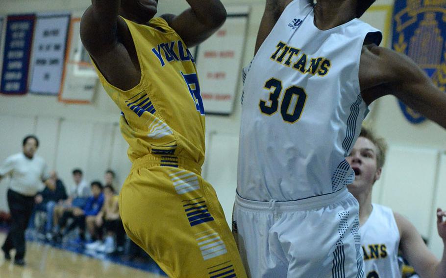 Yokota's Jimmy Dewberry puts up a shot against St. Mary's Satish Karthikeyan during Friday's Japan boys basketball game, won by the Panthers 52-32.