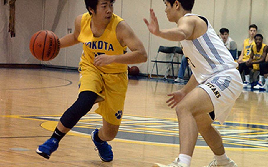 Yokota's Ken Baarde dribbles against St. Mary's Ricky Story during Friday's Japan boys basketball game, won by the Panthers 52-32.