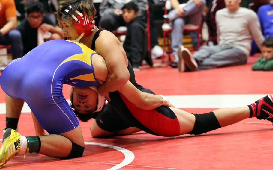 Nile C. Kinnick's Kameron Leon Guerrero gets the upper hand on St. Mary's Austin Koslow in the 168-pound final during Saturday's 25th Nile C. Kinnick Invitational "Beast of the Far East" Wrestling Tournament. Koslow decisioned Leon Guerrero 12-6.