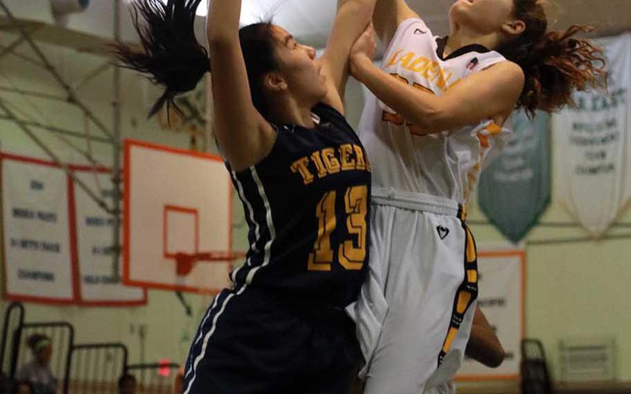 Kadena's Megan Kirby shoots over a Taipei American defender during Sunday's girls game in the 3rd Taipei American Basketball Exchange. The Panthers beat the Tigers 63-56.