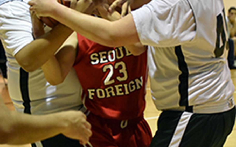 Daegu's Elijah Bembischew and Jack Zimmer corral Seoul Foreign's Justin Chung and the ball during Friday's Korea boys basketball game, won by the Crusaders 59-43.