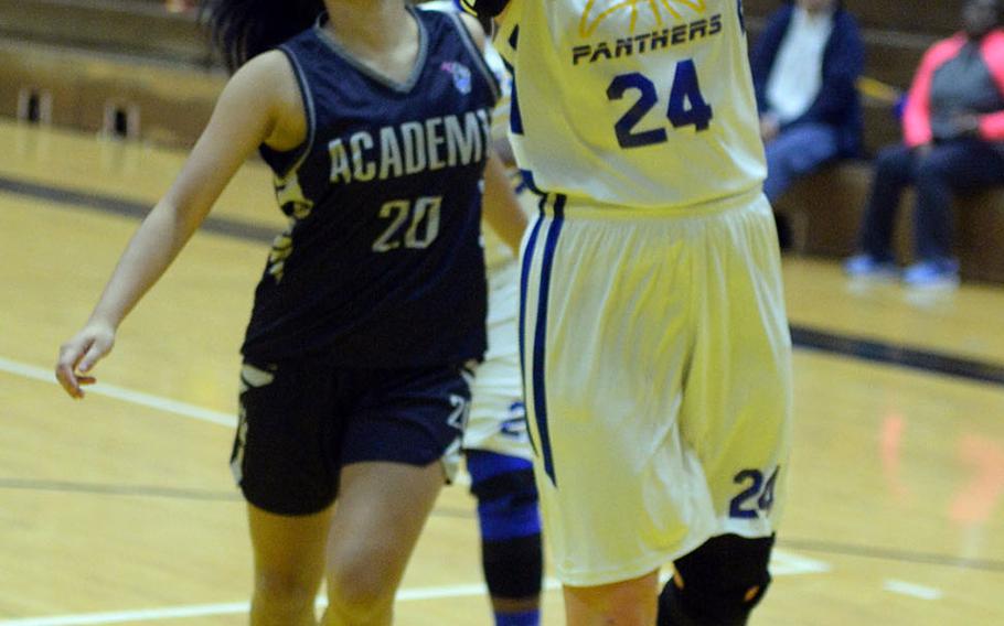 Yokota's Jordyn Logue drives for a layup ahead of Academy of Our Lady of Guam's Emilee Yamamoto during Friday's girls pool-play game in the 2nd American School In Japan Kanto Classic Basketball Tournament. The Panthers routed the Cougars 47-16.