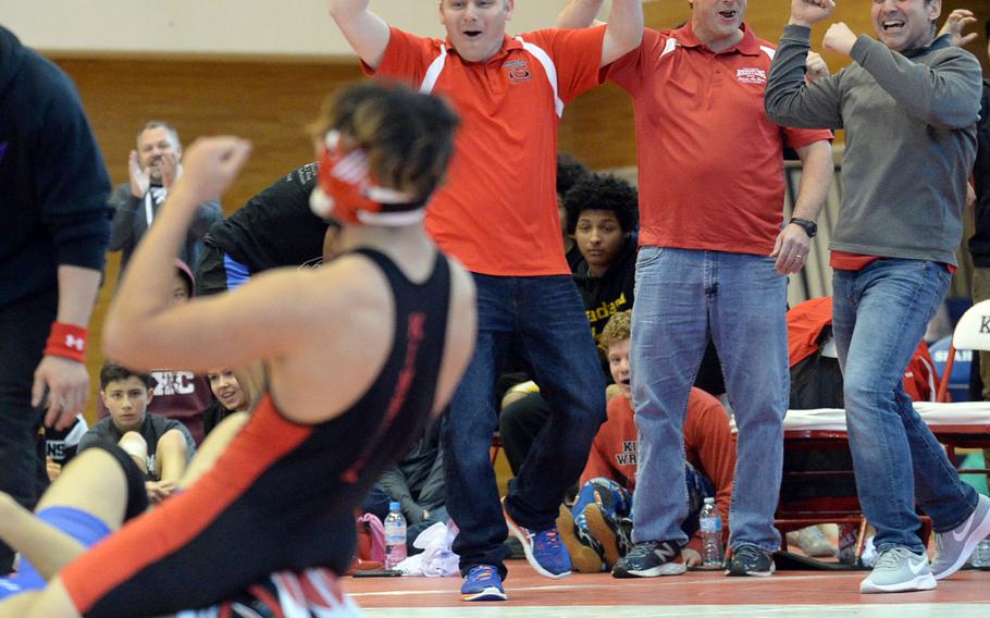 Nile C. Kinnick coaches Ray Wirth, Gary Wilson and Dan Joley join 168-pounder Kameron Leon Guerrero in celebrating his pinfall victory in 5 minutes, 52 seconds over St. Mary's Austin Koslow during Friday's individual portion of the 41st Far East High School Wrestling Tournament. 