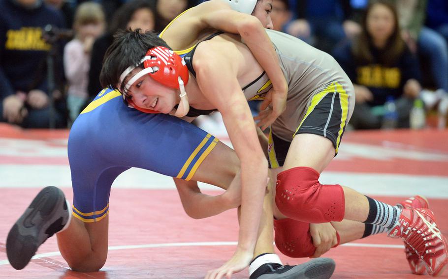 Nile C. Kinnick's John Lanzilotta tries to gain the edge on Jasjot Bedi at 101 pounds during Saturday's Far East Wrestling Tournament Division I dual-meet final. Lanzilotta won a 5-3 decision, and the Red Devils rallied to beat the Titans 30-28.