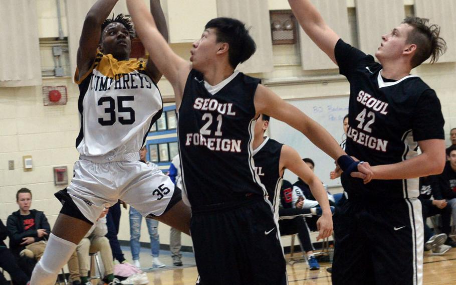 Humphreys' Jalen Hill shoots against Seoul Foreign's Paul Kim and Jonah Meyer during Friday's final in the Korea Blue Division boys basketball tournament. The Blackhawks routed the Crusaders 68-39.