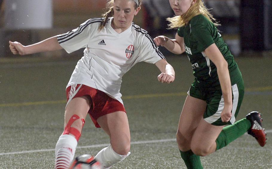 Nile C. Kinnick's Maggie Connelly boots a cross pass past Robert D. Edgren's Amber Aldridge during Friday's DODEA-Japan girls soccer match. The Red Devils clipped the Eagles 7-1.