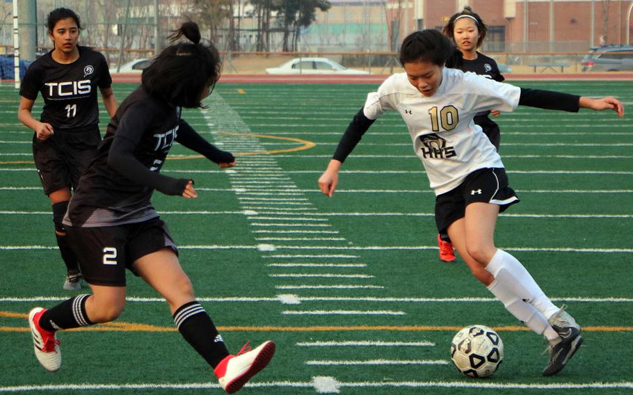 Humphreys' Ariel Stickar weaves her way between Taejon Christian defenders during Friday's Korea Blue girls soccer match. The Blackhawks won 5-1, continuing the team's best start in school history at 2-0-1.