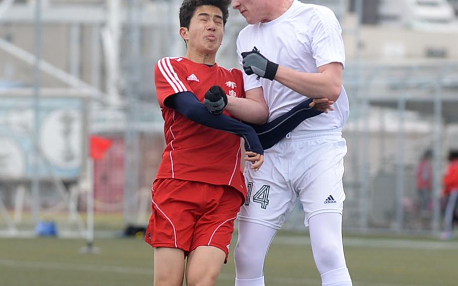 Nile C. Kinnick's Kai Sullivan and Robert D. Edgren's Cole Bodily go up to head the ball during Saturday's DODEA-Japan boys soccer match. The Red Devils blanked the Eagles 5-0.