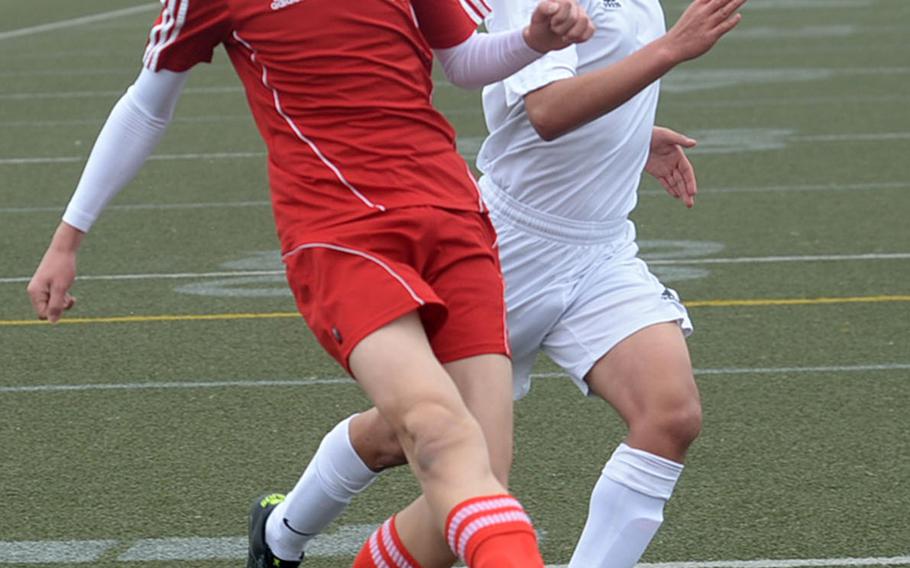 Nile C. Kinnick's Joey Hand fires a shot in front of Robert D. Edgren defender Andy Zarate during Saturday's DODEA-Japan boys soccer match. The Red Devils blanked the Eagles 5-0.