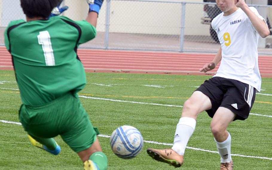 Kadena striker Brennon Slinger fires a shot past Misato Tech goalkeeper Seiya Nakamura during Saturday's Okinawa boys soccer match. The Panthers won 6-0.