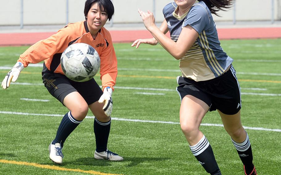 Kadena striker Phoebe Bills charges past Naha Commercial goalkeeper Shina Hamamoto toward the ball during Saturday's Okinawa girls soccer match. Bills did not score on the play. The Panthers won 5-0.