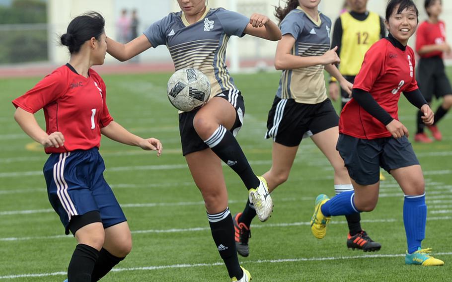 Kadena striker Adrianna Gomez tries to settle the ball between Naha Commercial defenders Ai Murayama and Michi Irei during Saturday's Okinawa girls soccer match. The Panthers won 5-0.