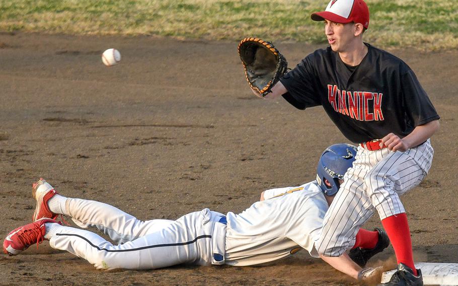Yokota baserunner Troy Barnes dives back to first base ahead of a pickoff throw to Nile C. Kinnick's Terrence Berg during Wednesday's DODEA-Japan/Kanto Plain baseball game, won by the Red Devils 10-6 in eight innings.