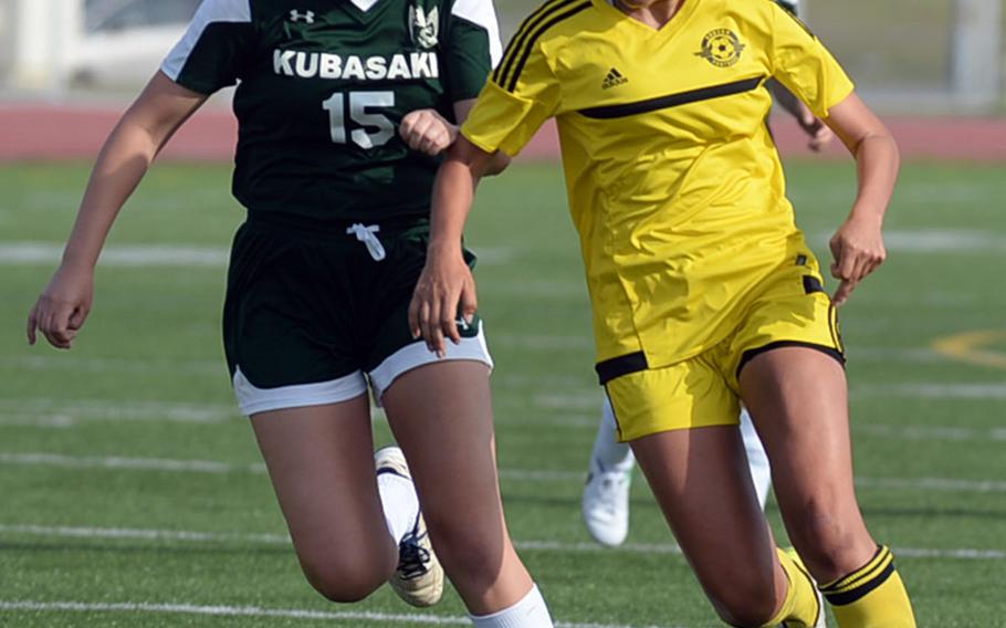 Kubasaki's Hanna Ervasti and Kadena's Adrianna Gomez chase the ball during Saturday's Okinawa girls soccer match. The Panthers won 3-0.