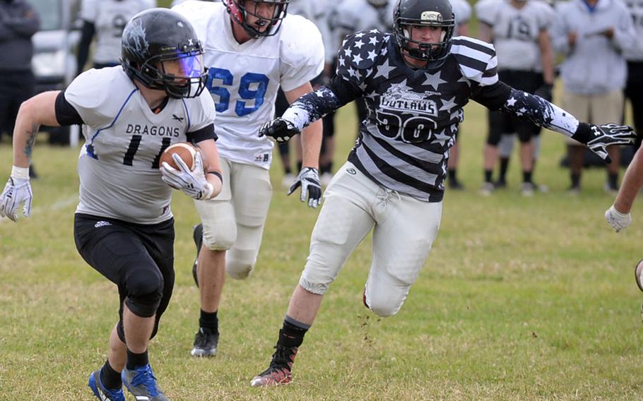 Okinawa Dragons running back Toby Queen looks for running room against Hansen Outlaws' Aaren Preston during Saturday's USFJ-AFL game, won by the Outlaws 14-12.