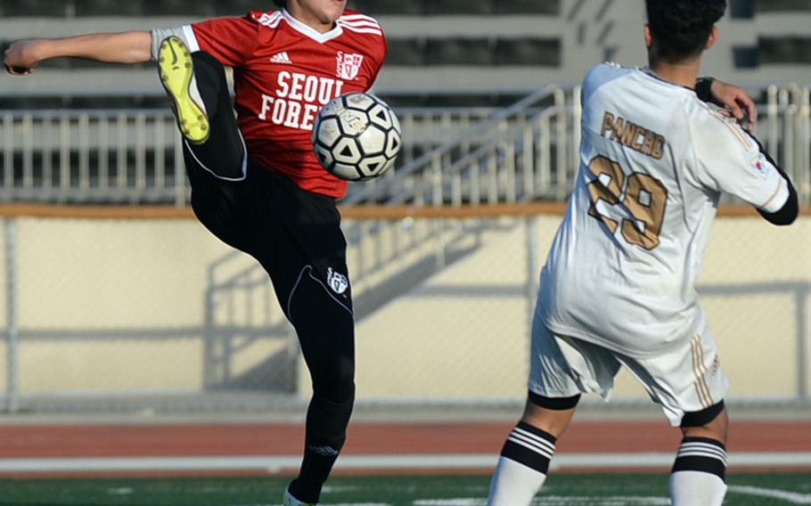 Seoul Foreign's Martin Kim tries to settle the ball in front of Humphreys' Christian Saaveda during Wednesday's Korea Blue boys soccer match, won by the Crusaders 9-2.