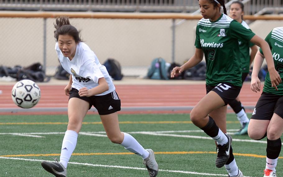 Humphreys' Arielle Stickar launches a shot at the Daegu net as Warriors' Yasmine Guilfoyle gives chase during Friday's Korea Blue girls soccer match, won by the Blackhawks 4-0.
