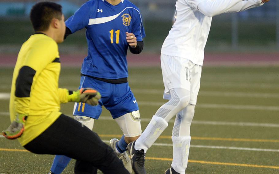 Robert D. Edgren's Dakota Padilla heads the ball in front of Yokota's Manny Mptias and Edgren keeper Cyril Yalung in Friday's DODEA Japan boys soccer match. The teams played to a 1-1 draw.