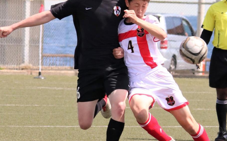 Zama's John Dowdell and Nile C. Kinnick's Cael Bowen scuffle for the ball during Thursday's pool-play match in the DODEA-Japan boys soccer tournament, won by the Red Devils 6-0.