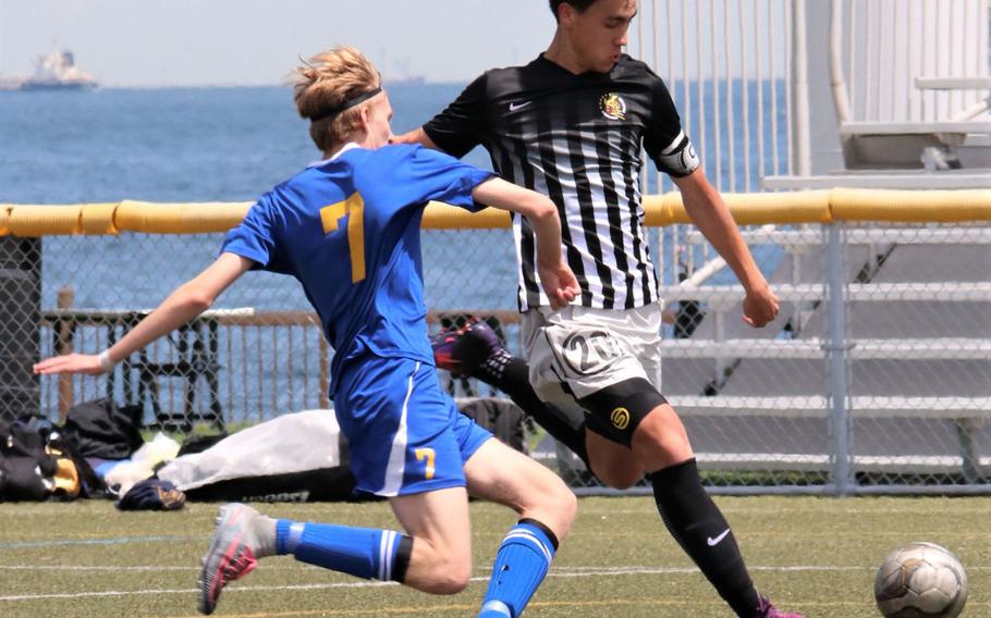 Matthew C. Perry's Kai Lange boots the ball against Yokota's Tylir Meyer during Thursday's pool-play match in the DODEA-Japan boys soccer tournament, won by the Samurai 4-1.
