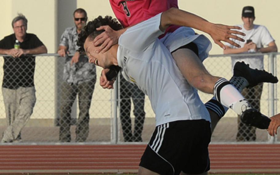 Kubasaki's Jack Boran climbs over the back of Kadena's Nao Heckerman to head the ball during Friday's Okinawa boys soccer match, won by the Dragons 1-0.