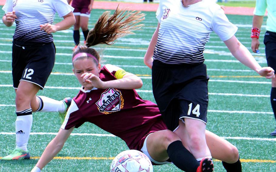 Zama's Abby Logan and Matthew C. Perry's Micayla Feltner get their legs tangled during Monday's pool-play match in the Far East Division II Soccer Tournament. The Samurai edged the Trojans 3-1.
