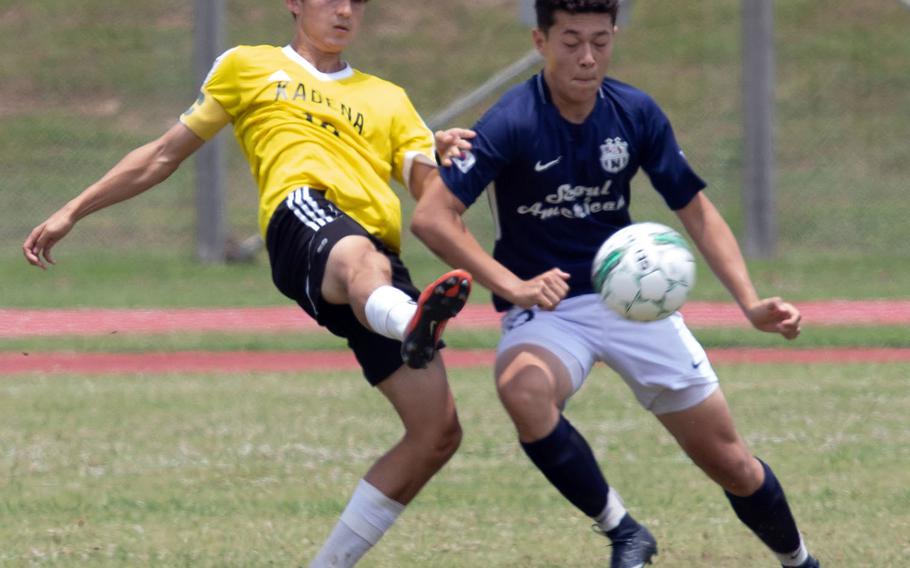 Kadena's Kian Smith and Seoul American's Ben Nagy scuffle for the ball during Monday's round-robin match in the Far East Division I boys soccer tournament. The Panthers won 1-0.
