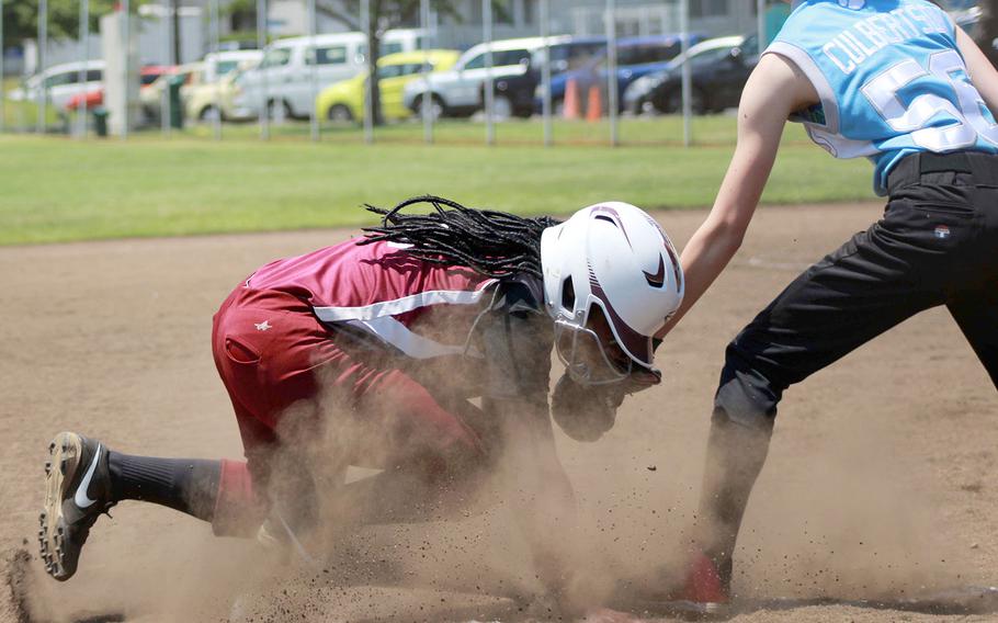 Perry's Valarie Thomas dives back to the bag ahead of the tag by Osan's Chloe Culbertson during Tuesday's knockout-round game in the Far East Division II softball tournament. The Samurai won 12-3.
