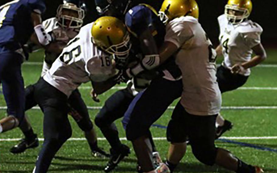 Guam High running back Sincere Powell gets sandwiched by two Tiyan defenders.