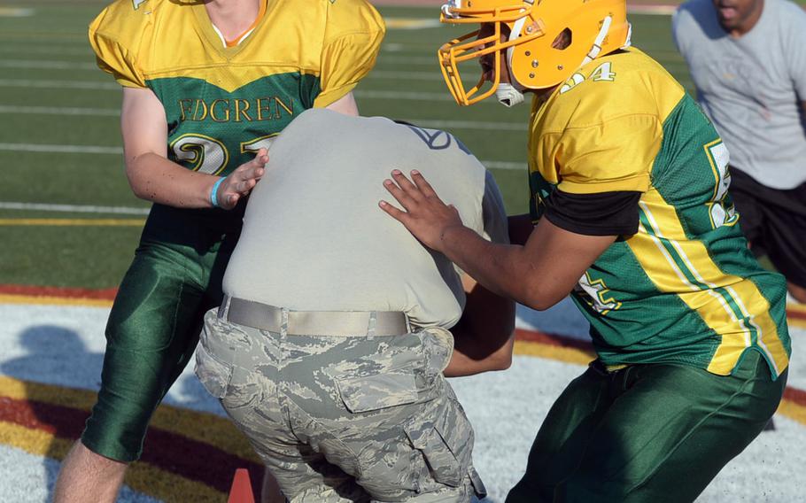 Eagles defenders Brad McCollum and Jason Dudley practice tackling techniques.