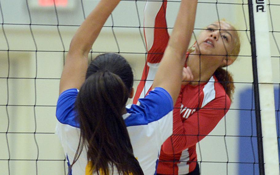 Nile C. Kinnick outside hitter Sontti Sesay hits a ball through the block of Yokota's Jaeana Reyes. The Red Devils beat the Panthers in four sets on Wednesday.