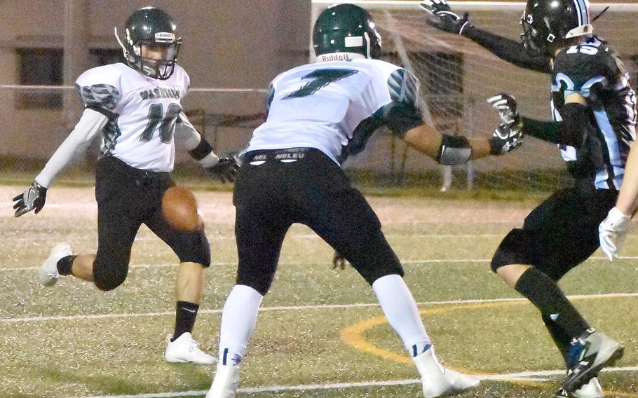 Daegu punter Kekai Chun-Andrade boots the ball ahead of the rush of Osan's Zachary Johnson as Warrior teammate Ethan Rodriguez tries to block.