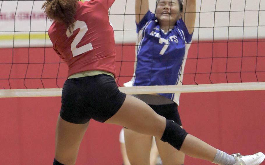 Christian Academy Japan's Keziah Sou tries to block a spike by Nile C. Kinnick's Sontti Sesay during the Knights' five-set win Tuesday over the Red Devils.