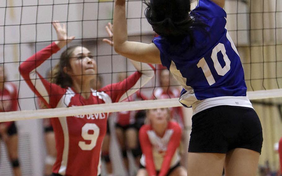 Christian Academy Japan's Mariko Maeda prepares to spike against Nile C. Kinnick's Melissa Rose during the Knights' five-set win Tuesday over the Red Devils.
