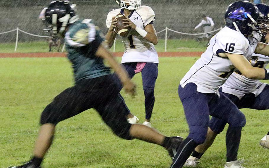 Guam High quarterback Travon Jacobs looks to throw in a driving rain at John F. Kennedy's Ramsey Field.