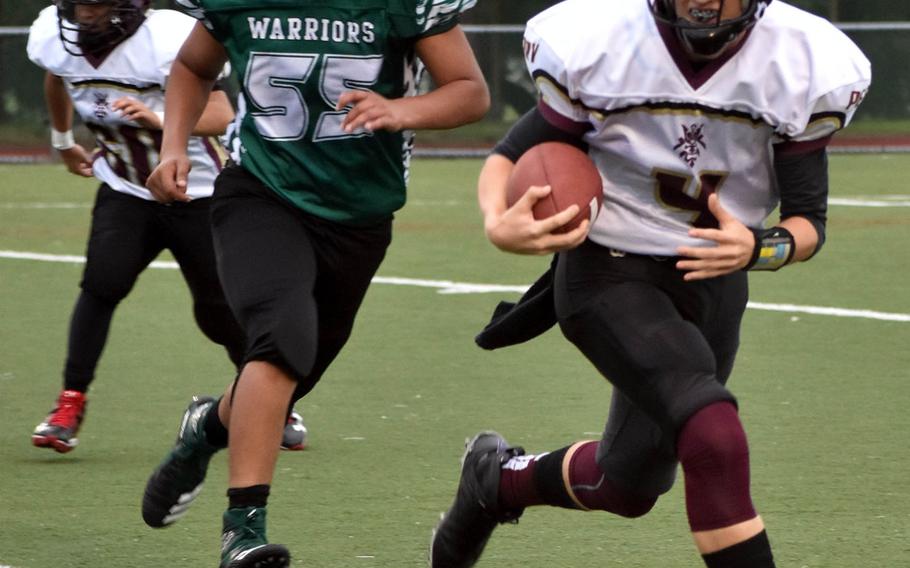 Matthew C. Perry quarterback Jackson Ramp tries to avoid the tackle of Daegu's Rodrigo Roque-Aquino.