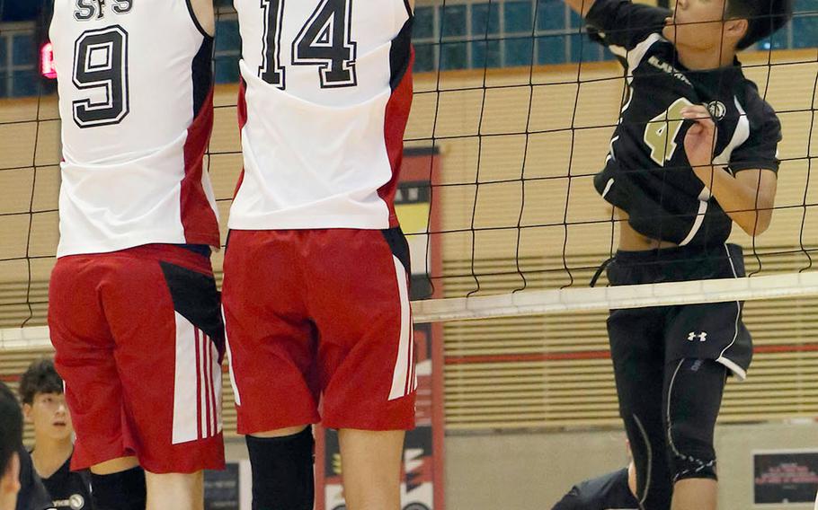 Humphreys' Cullen Areniego tries to hit through the double block by Seoul Foreign's Matt Daly and Joseph Kang during Wednesday's three-set victory by the Crusaders over the Blackhawks.