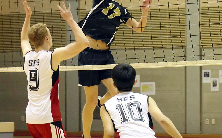 Humphreys' Connor Coyne skies for the ball against Seoul Foreign's Matt Daly and Josh Ko during Wednesday's three-set victory by the Crusaders over the Blackhawks.