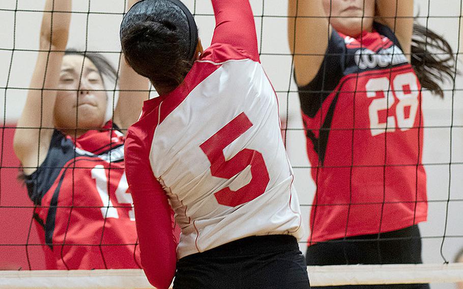 Nile C. Kinnick's Lynelle Adepoju tries to hit through the double block of Emi Ishikawa and Yoko Hara of St. Maur during Wednesday's three-set victory by the Red Devils over the Cougars.
