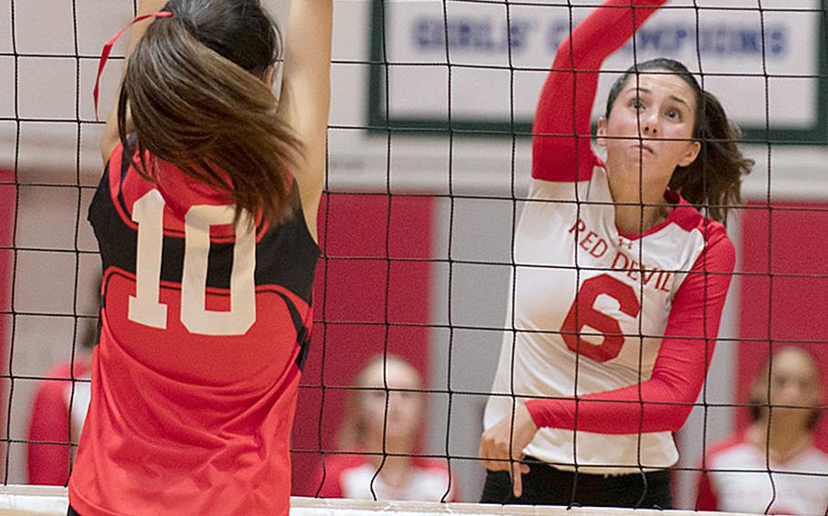 Nile C. Kinnick's Emma Stevens hits the ball past St. Maur's Rei Ozawa during Wednesday's three-set victory by the Red Devils over the Cougars.