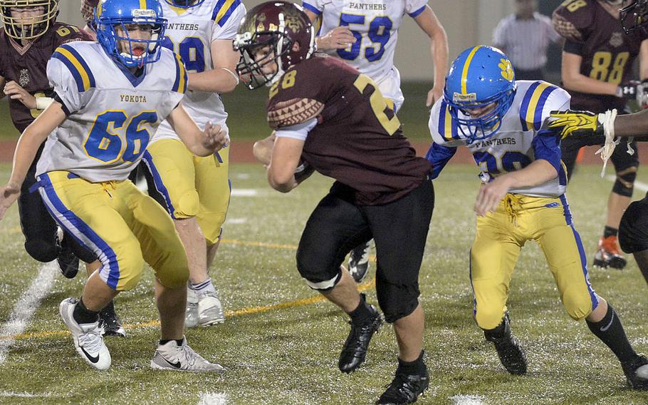 Matthew C. Perry running back Cameron Penn finds daylight between Yokota defenders Kai Salazar and Jared Brady.