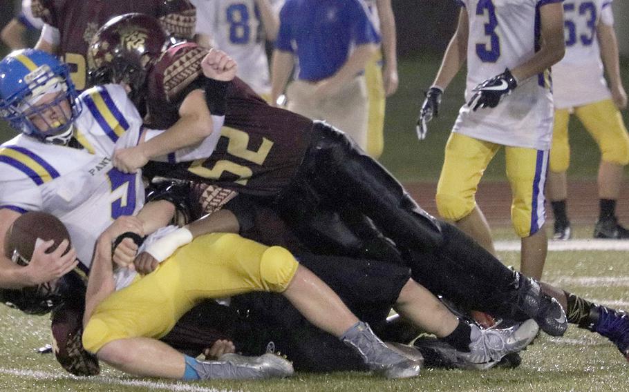 Yokota quarterback Ethan Gaume gets brought down by Matthew C. Perry defender Parker Staley.