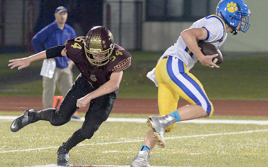 Yokota quarterback Ethan Gaume eludes Matthew C. Perry defender Hunter Staley.