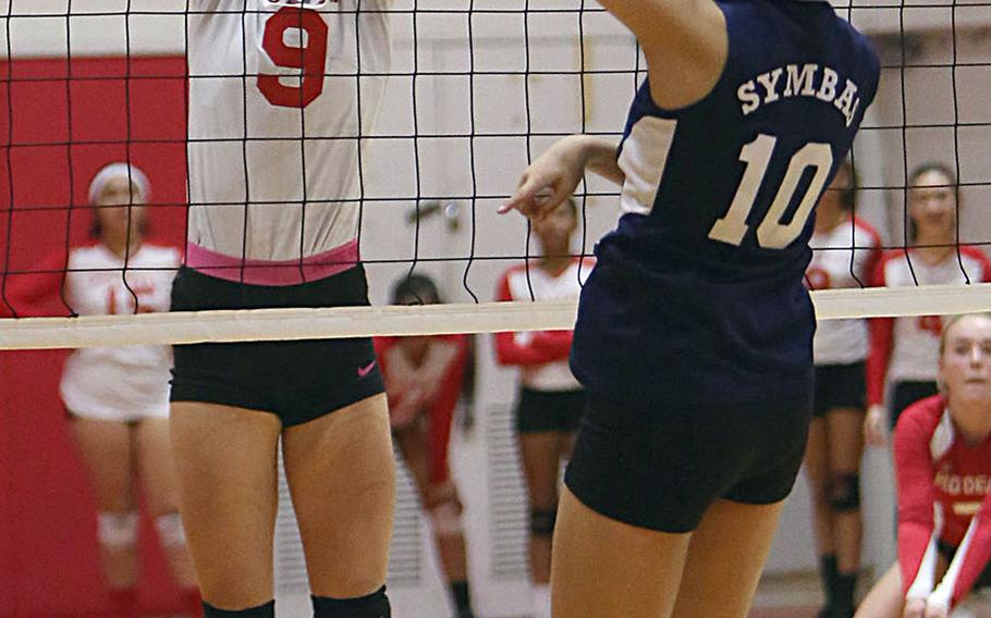 Nile C. Kinnick's Melissa Rose blocks a shot by Sacred Heart's Karin Kosugi -- one of three blocks by Rose during Thursday's three-set win by the Red Devils over the Symbas.
