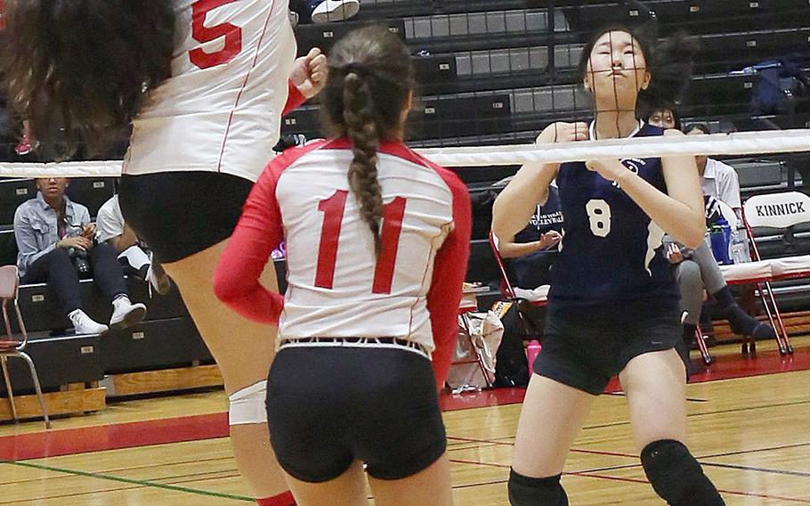 Nile C. Kinnick's Tori Osterbrink slams the ball past Sacred Heart's Erika Takei during Thursday's three-set win by the Red Devils over the Symbas.