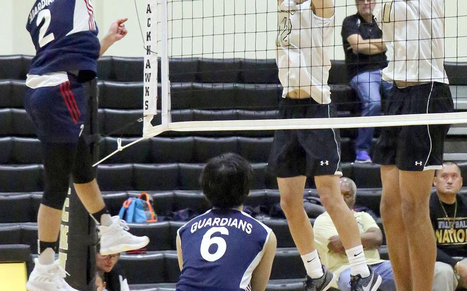 Max Choi of Yongsan drives the ball through the block of Humphreys' Jonas Lee and Collin Metcalf during Friday's four-set win by the Guardians over the Blackhawks.