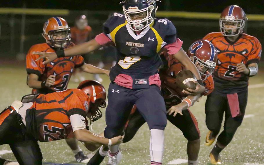 Guam High running back RaSean Jacobs tries to knife his way between Okkodo defenders.